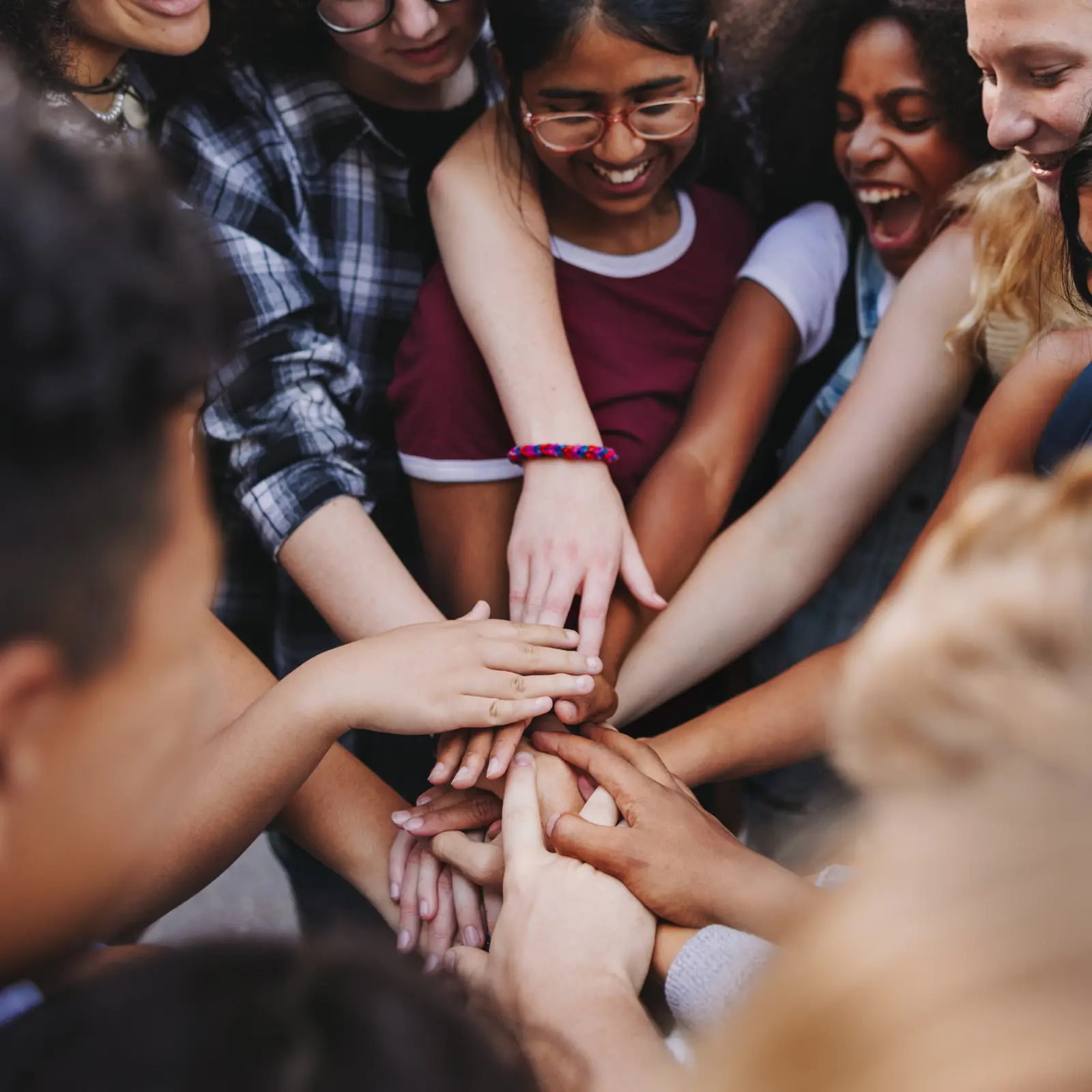 Des jeunes réunissant leurs mains dans un geste collectif